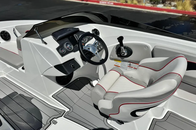 Slide: The Image of 2021 Tahoe T700 boat cockpit with steering wheel, gauges, and cushioned seat. - 22
