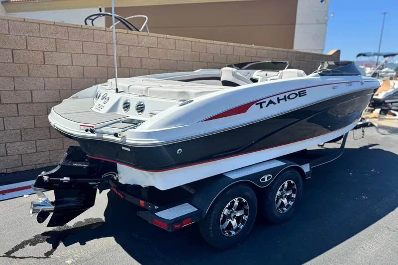 Slide: The Image of 2021 Tahoe T700 boat on trailer, parked outdoors, showcasing sleek design and modern features. - 5