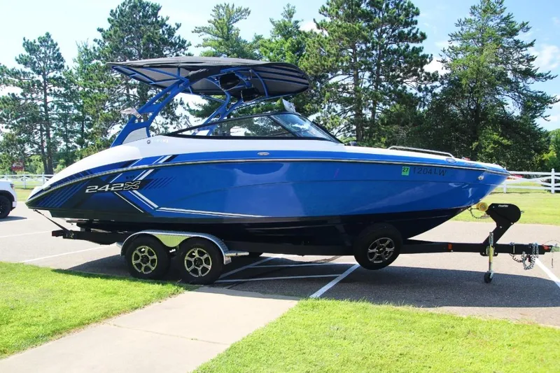 Slide: The Image of 2019 Yamaha Boats 242X in blue, parked on a trailer in a scenic outdoor setting. - 3