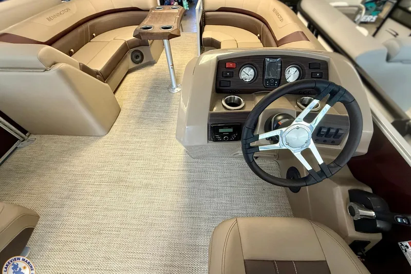 Slide: The Image of 2025 Bennington 22 SXSR boat interior with steering wheel, dashboard, and seating area. - 2