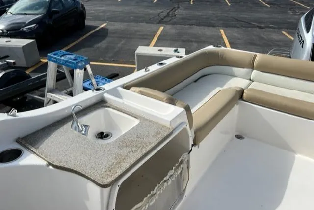 Slide: The Image of 2019 Key West 239 DFS boat interior with seating and sink in a parking lot. - 10