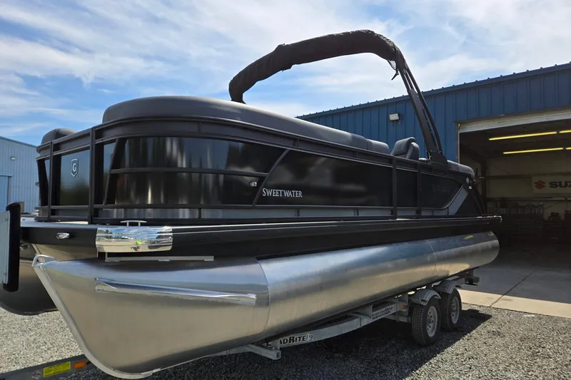 Slide: The Image of 2026 Godfrey SWEETWATER 2286 SB pontoon boat on trailer outside a blue building. - 11