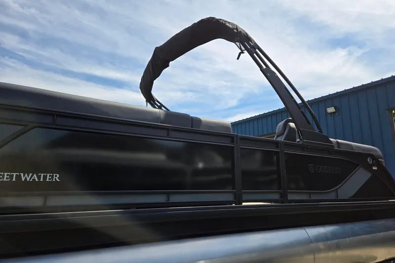 Slide: The Image of 2026 Godfrey SWEETWATER 2286 SB pontoon boat with sleek black design and canopy. - 12