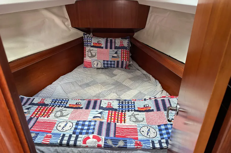 Slide: The Image of Cozy cabin interior of 2000 Beneteau Oceanis 36 CC with nautical-themed bedding. - 29