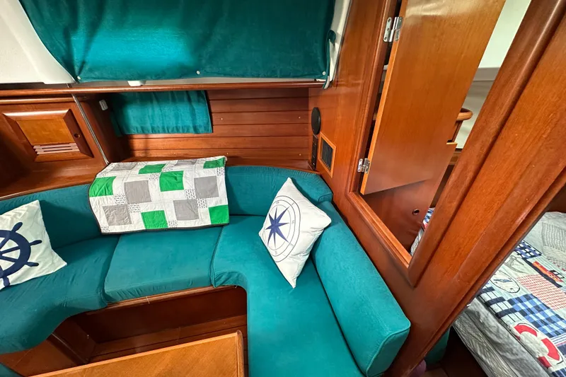 Slide: The Image of Interior of 2000 Beneteau Oceanis 36 CC sailboat with teal seating and nautical decor. - 30