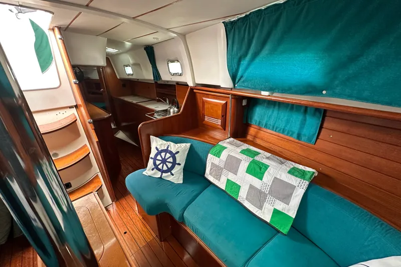 Slide: The Image of Interior of 2000 Beneteau Oceanis 36 CC sailboat with teal seating and nautical decor. - 32