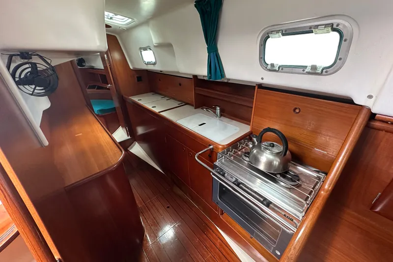 Slide: The Image of Interior of 2000 Beneteau Oceanis 36 CC sailboat with wooden cabinetry and compact kitchen. - 35
