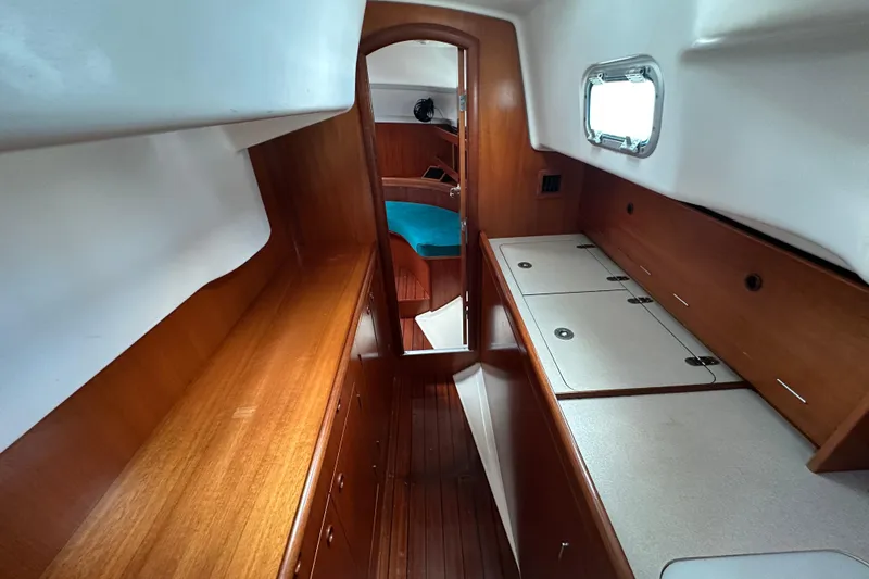 Slide: The Image of Interior of 2000 Beneteau Oceanis 36 CC sailboat with wood finish and compact design. - 36