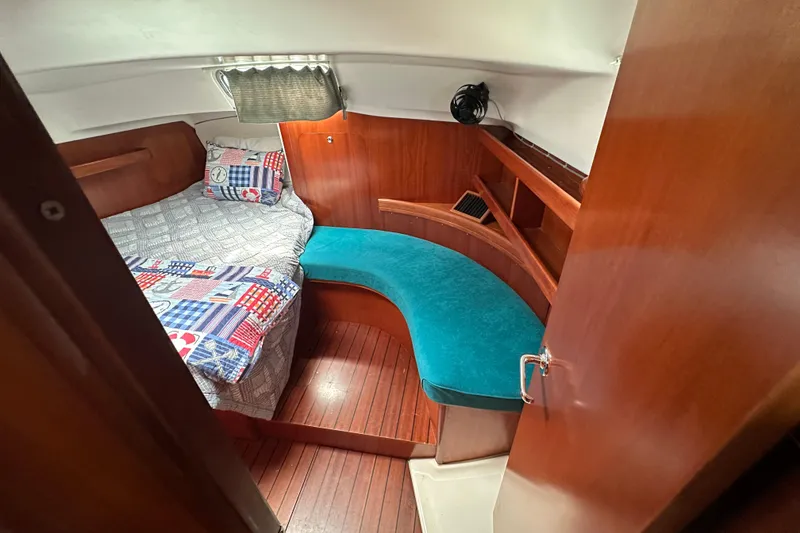 Slide: The Image of Cozy cabin interior of 2000 Beneteau Oceanis 36 CC with wooden finish and colorful bedding. - 37