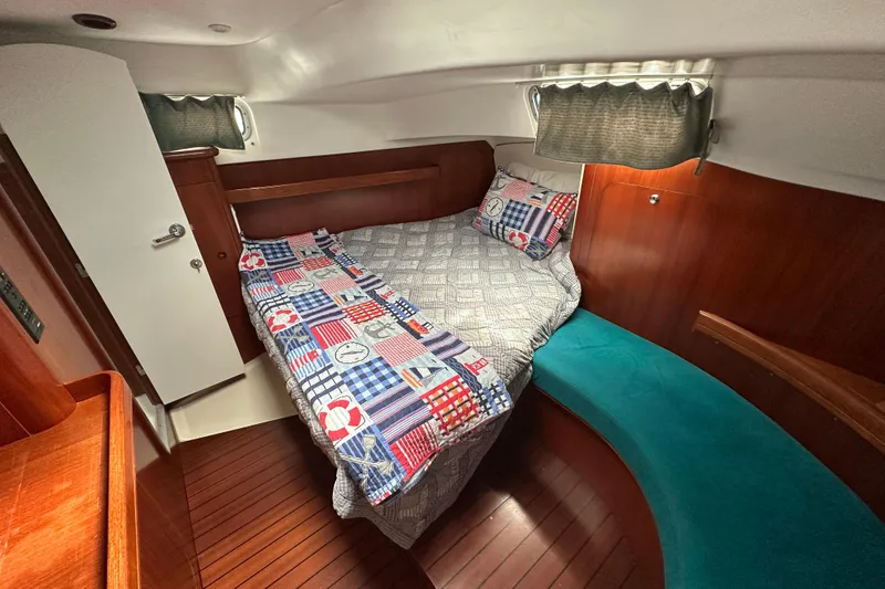 Slide: The Image of Cozy cabin interior of 2000 Beneteau Oceanis 36 CC with colorful bedding and wood finish. - 38