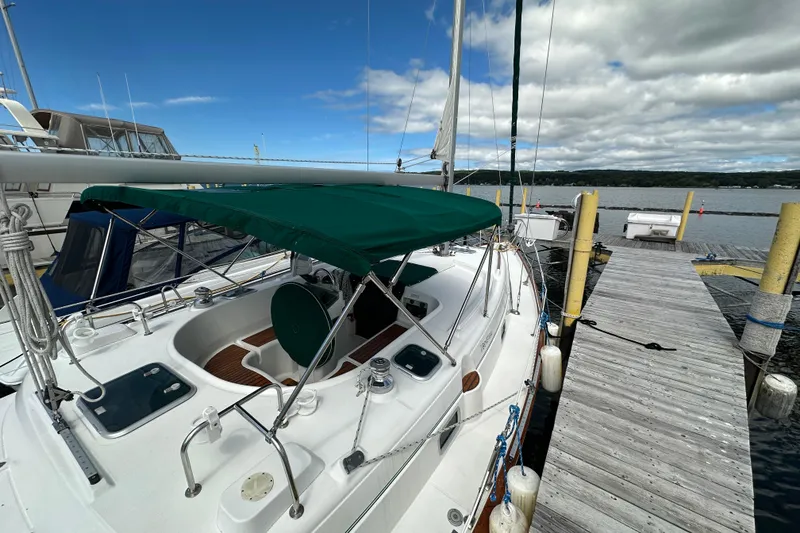 Slide: The Image of Beneteau Oceanis 36 CC sailboat docked, 2000 model, with green canopy and clear sky. - 6