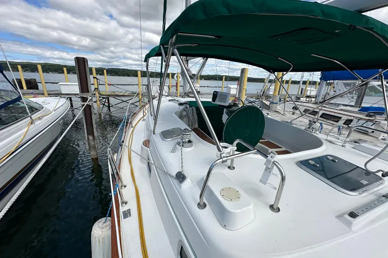 Slide: The Image of 2000 Beneteau Oceanis 36 CC sailboat docked at marina, featuring green canopy. - 9