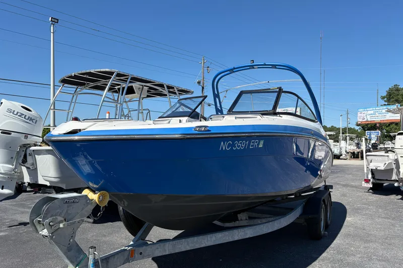 The Image of 2020 Yamaha Boats AR240 in blue on trailer, parked outdoors under clear sky. - 0