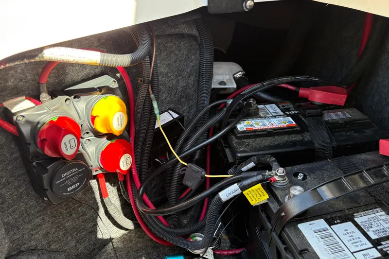 Slide: The Image of 2020 Yamaha Boats AR240 battery compartment with wiring and switches. - 17