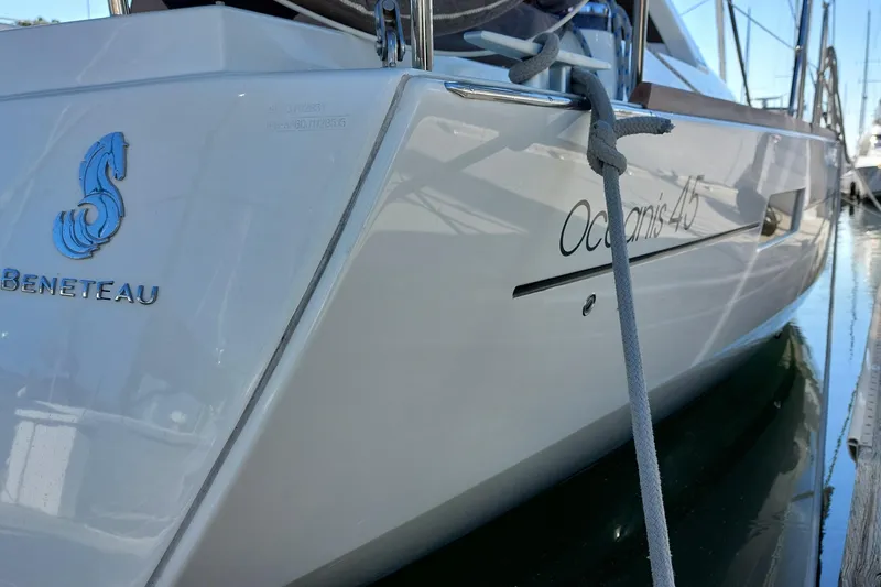 Slide: The Image of 2015 Beneteau Oceanis 45 yacht docked, showcasing sleek design and branding. - 12