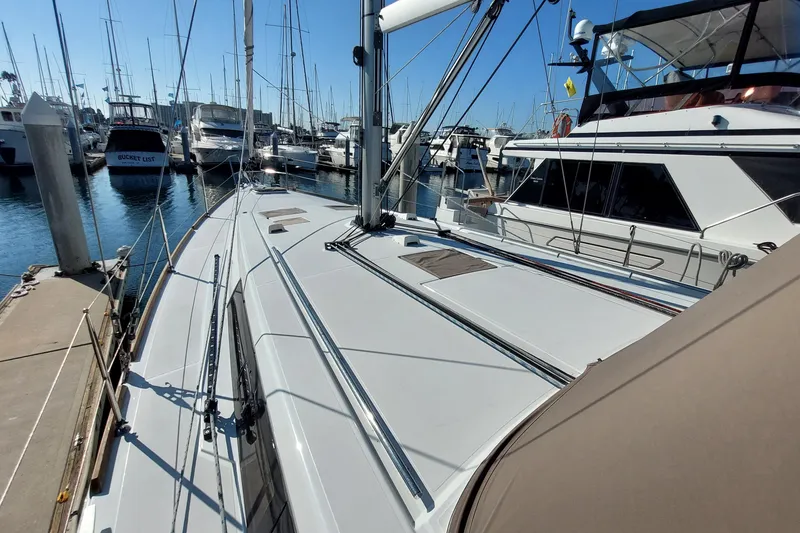 Slide: The Image of 2015 Beneteau Oceanis 45 sailboat docked in a marina, surrounded by other boats. - 16