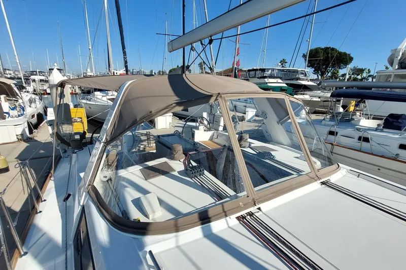 Slide: The Image of 2015 Beneteau Oceanis 45 sailboat docked in marina, featuring spacious deck and canopy. - 18