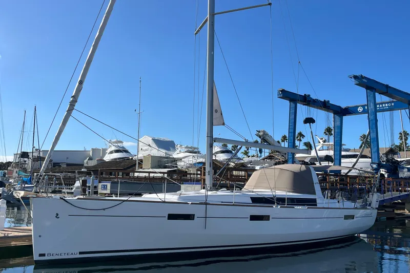 Slide: The Image of 2015 Beneteau Oceanis 45 sailboat docked at marina under clear blue sky. - 2
