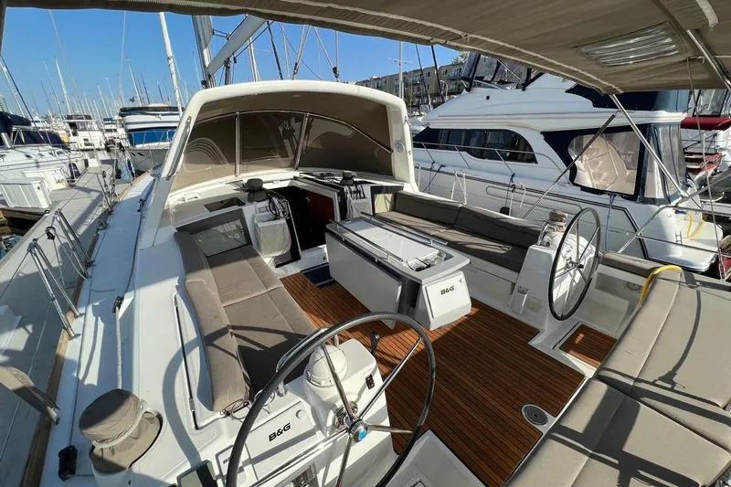 Slide: The Image of 2015 Beneteau Oceanis 45 sailboat with spacious cockpit and dual steering wheels in marina. - 25
