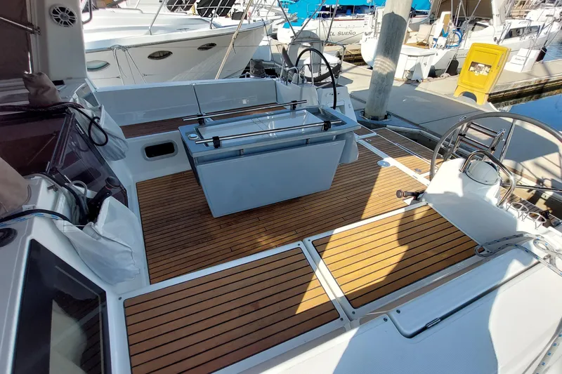 Slide: The Image of Beneteau Oceanis 45 yacht deck, 2015 model, featuring sleek wood finish and dual steering wheels. - 28
