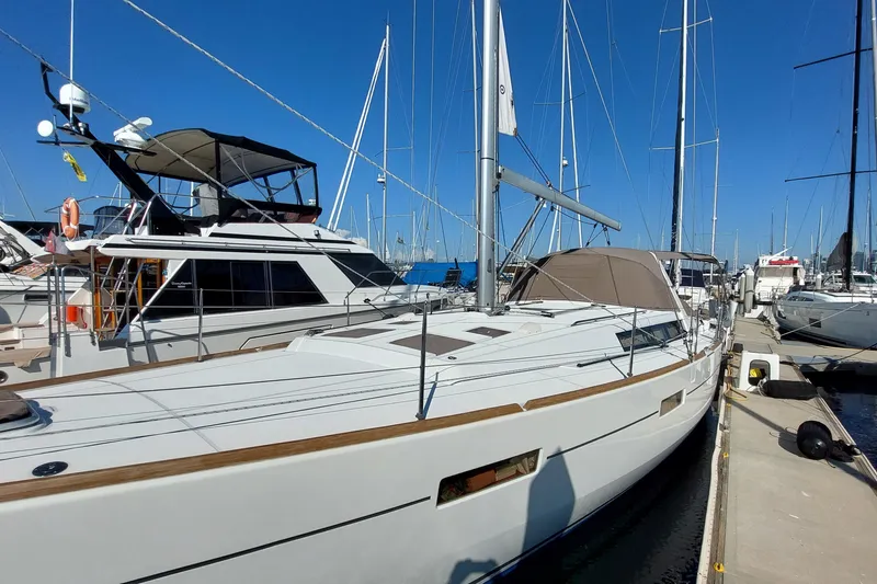 Slide: The Image of 2015 Beneteau Oceanis 45 sailboat docked at marina under clear blue sky. - 4