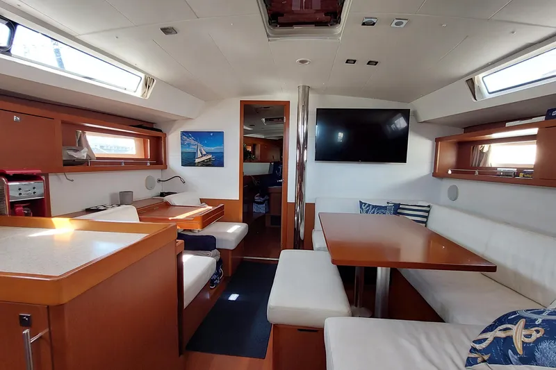 Slide: The Image of Interior of 2015 Beneteau Oceanis 45 yacht with modern dining area and seating. - 49