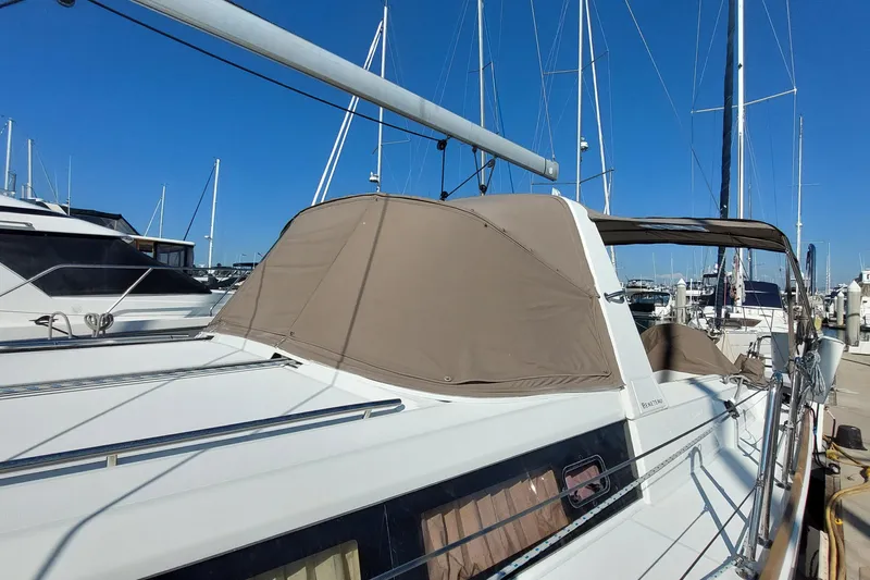 Slide: The Image of 2015 Beneteau Oceanis 45 sailboat docked at marina, featuring beige canopy and sleek design. - 5