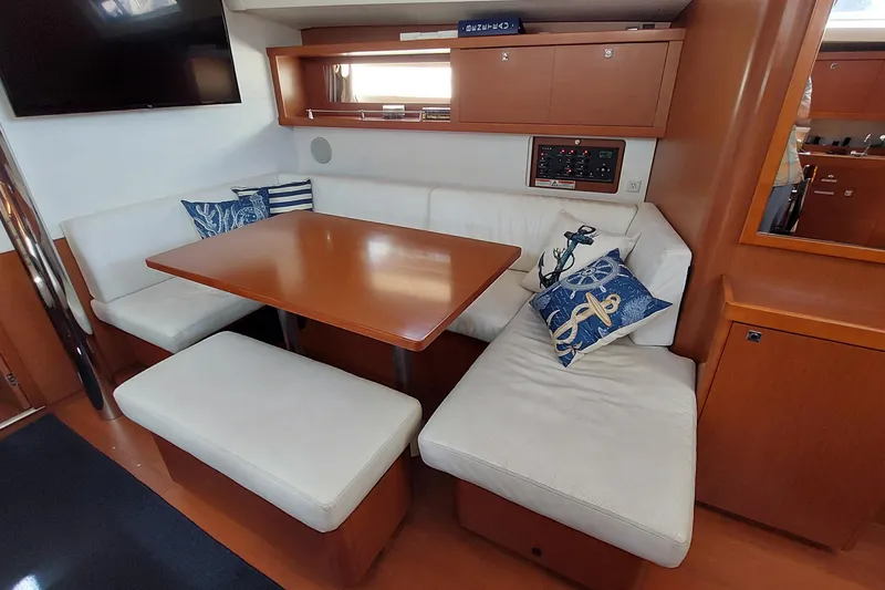 Slide: The Image of Interior of 2015 Beneteau Oceanis 45 yacht with cozy seating and nautical decor. - 50
