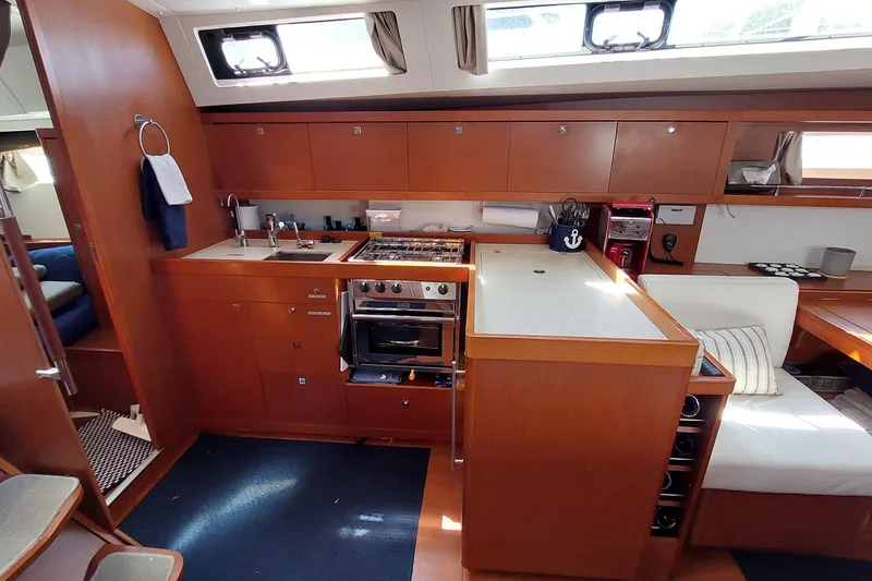 Slide: The Image of Interior of 2015 Beneteau Oceanis 45 yacht, featuring a modern kitchen and seating area. - 51