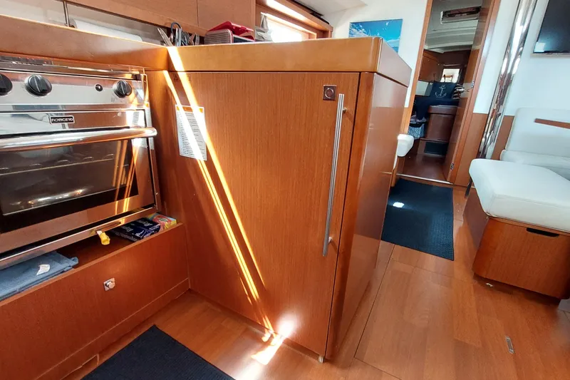 Slide: The Image of Interior of 2015 Beneteau Oceanis 45 yacht, featuring a modern kitchen and seating area. - 57