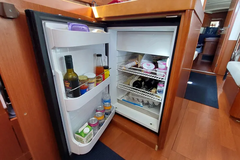 Slide: The Image of Open refrigerator in 2015 Beneteau Oceanis 45 yacht, stocked with beverages and food items. - 58