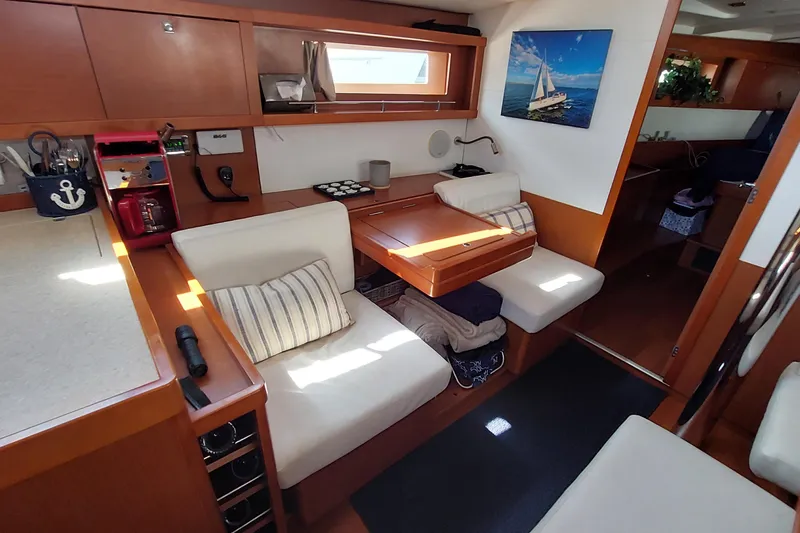 Slide: The Image of Interior of 2015 Beneteau Oceanis 45 yacht with cozy seating and nautical decor. - 59