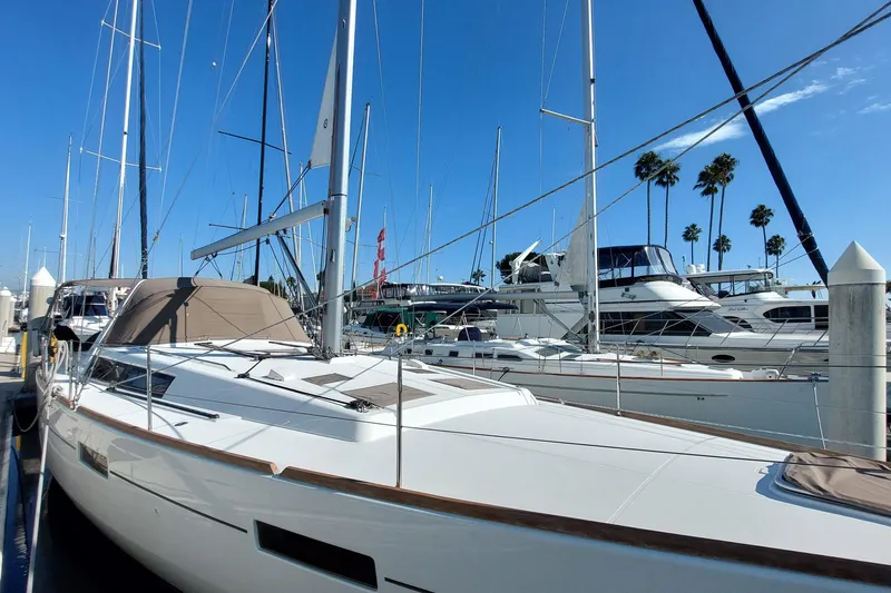 Slide: The Image of 2015 Beneteau Oceanis 45 sailboat docked at marina under clear blue sky. - 6