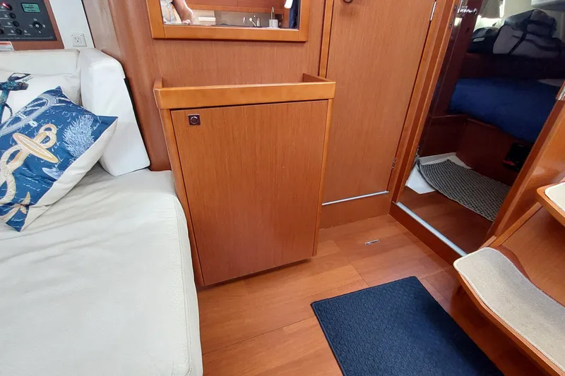 Slide: The Image of Interior of 2015 Beneteau Oceanis 45 yacht with wooden cabinetry and nautical-themed decor. - 62
