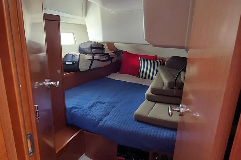 Slide: The Image of Cozy cabin interior of 2015 Beneteau Oceanis 45 with blue bedding and luggage. - 68