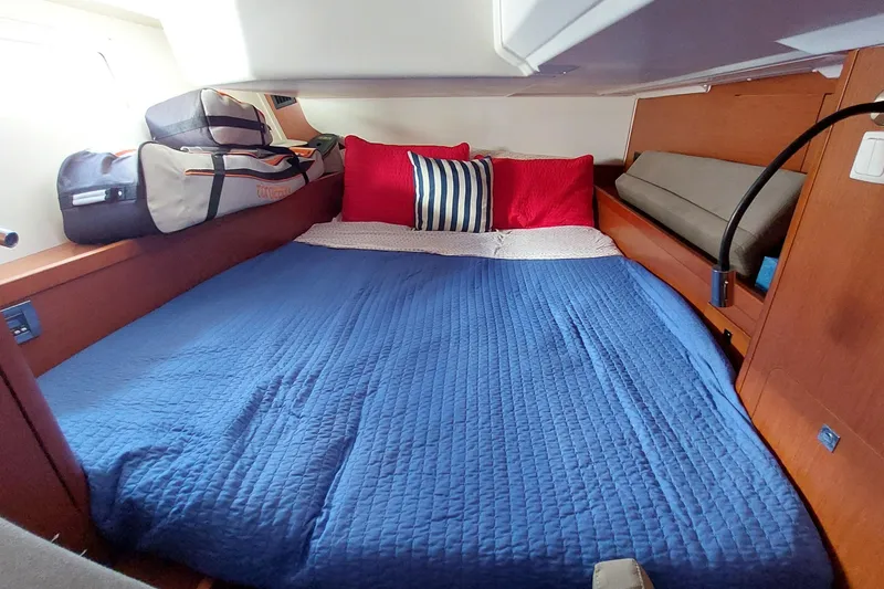 Slide: The Image of Cozy cabin interior of 2015 Beneteau Oceanis 45 with blue bedding and red pillows. - 69