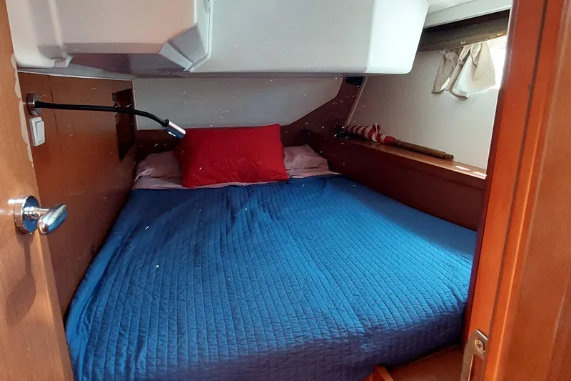 Slide: The Image of Cozy cabin interior of 2015 Beneteau Oceanis 45 with blue bedding and red pillow. - 71