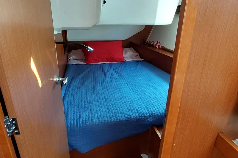 Slide: The Image of Cozy cabin interior of 2015 Beneteau Oceanis 45 with blue bedding and red pillow. - 73