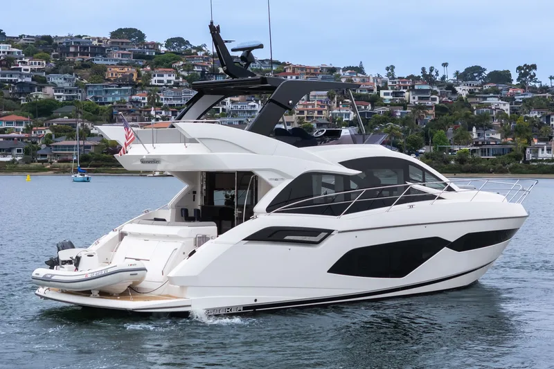 Slide: The Image of 2021 Sunseeker Manhattan 55 yacht cruising near coastal homes. - 10