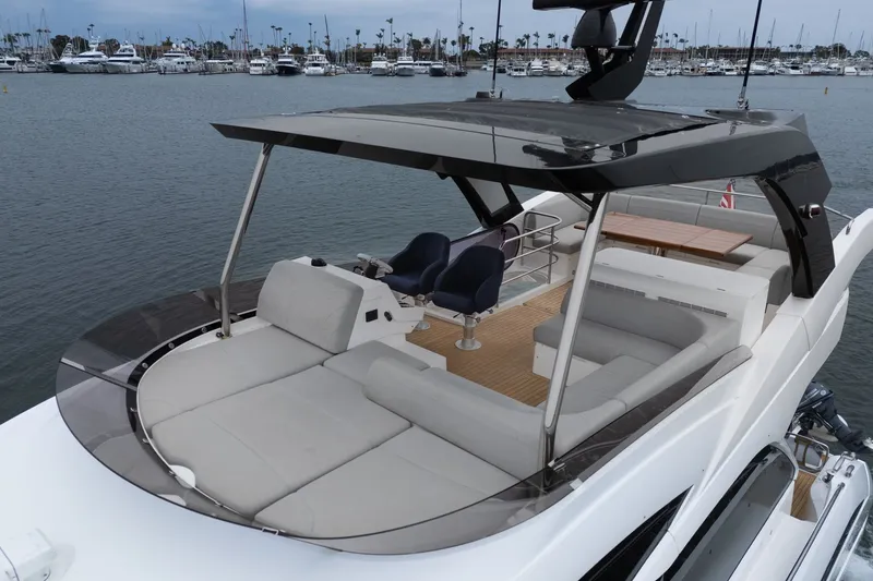 Slide: The Image of Luxurious 2021 Sunseeker Manhattan 55 yacht with spacious deck and seating area in marina. - 13