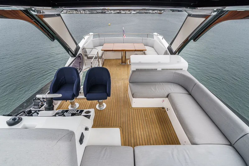 Slide: The Image of Luxurious 2021 Sunseeker Manhattan 55 yacht interior with seating and helm, overlooking water. - 16