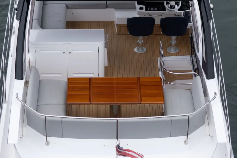 Slide: The Image of Sunseeker Manhattan 55 yacht deck with seating and wooden table, 2021 model. - 25
