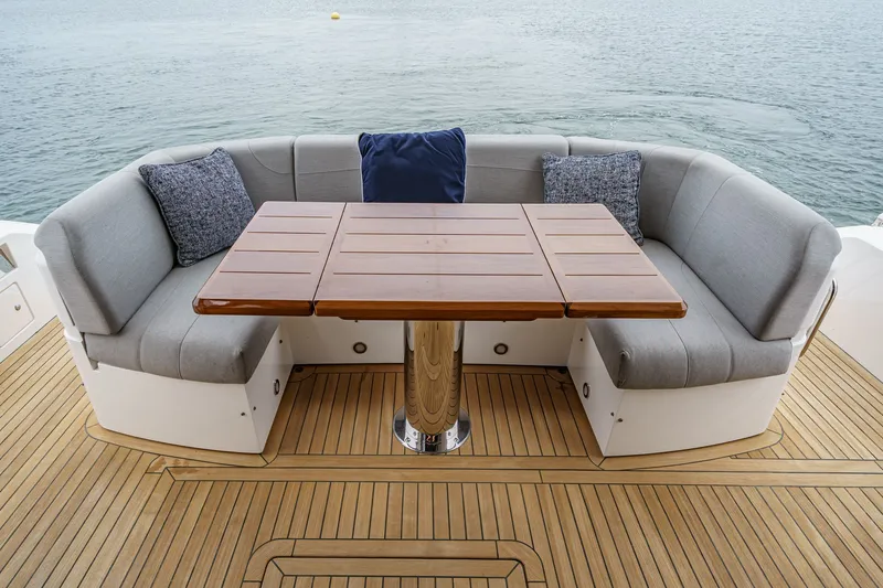 Slide: The Image of Luxury seating area on 2021 Sunseeker Manhattan 55 yacht with wooden table and cushions. - 38