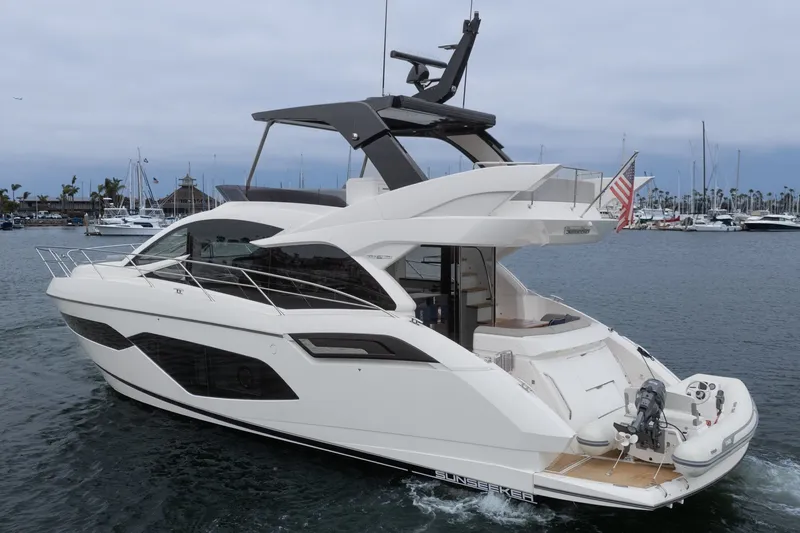 Slide: The Image of 2021 Sunseeker Manhattan 55 yacht cruising in a marina, showcasing sleek design and luxury features. - 5