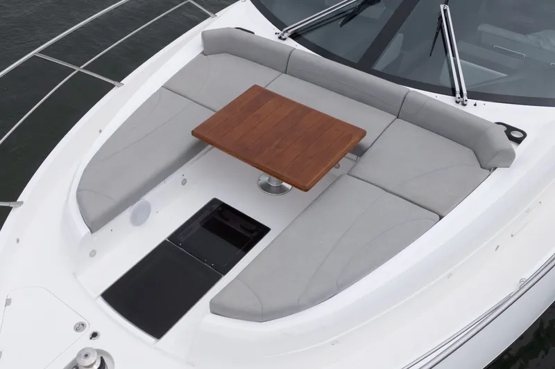 Slide: The Image of 2021 Sunseeker Manhattan 55 yacht with cushioned seating and wooden table on deck. - 8