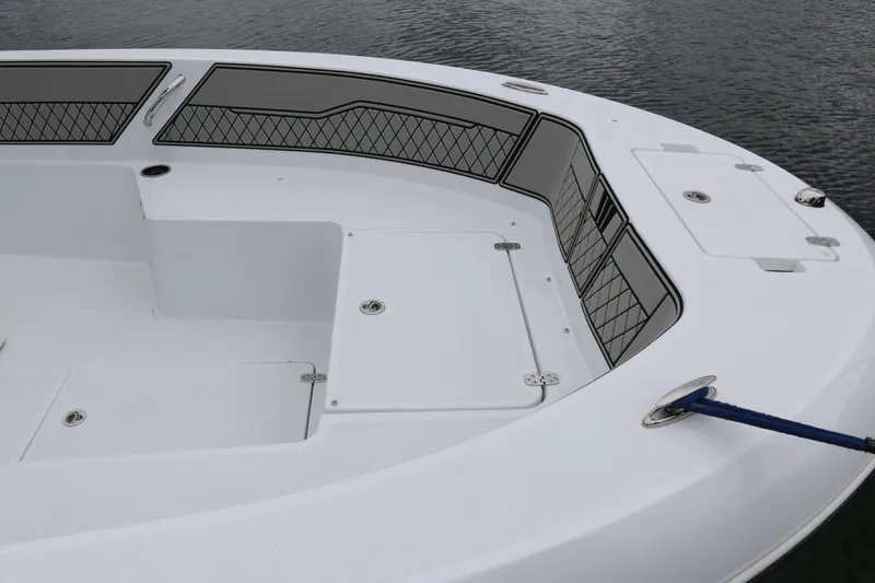Slide: The Image of 2025 Wellcraft 202 Fisherman boat deck with storage compartments and railing, docked on water. - 10