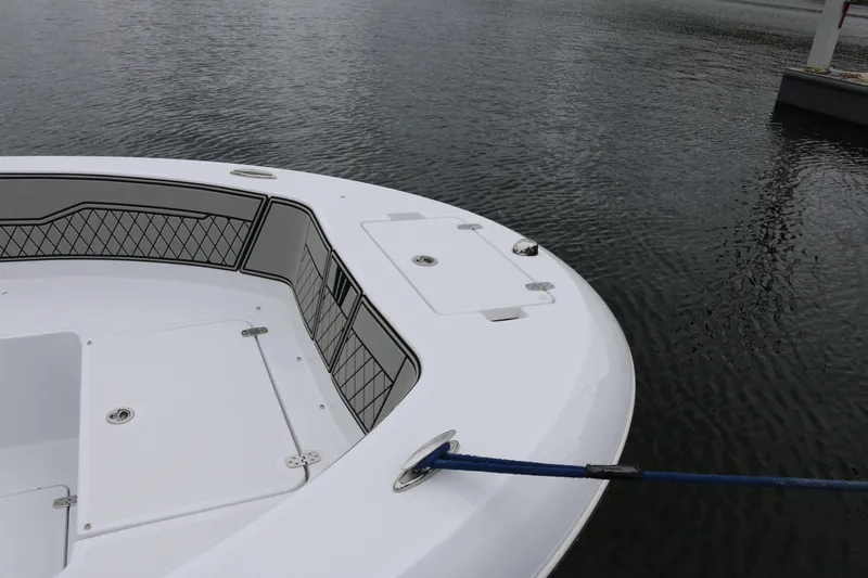 Slide: The Image of 2025 Wellcraft 202 Fisherman boat bow, docked on calm water. - 11