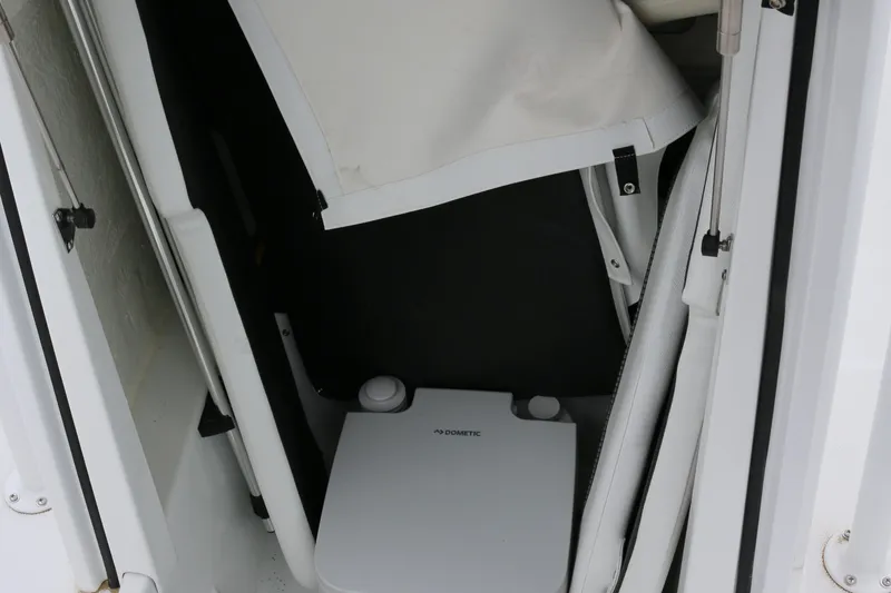 Slide: The Image of Interior of 2025 Wellcraft 202 Fisherman boat, featuring a compact Dometic toilet. - 33