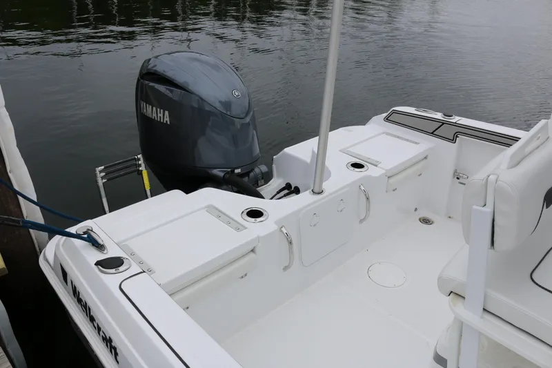 Slide: The Image of 2025 Wellcraft 202 Fisherman boat with Yamaha outboard motor, docked on calm water. - 6