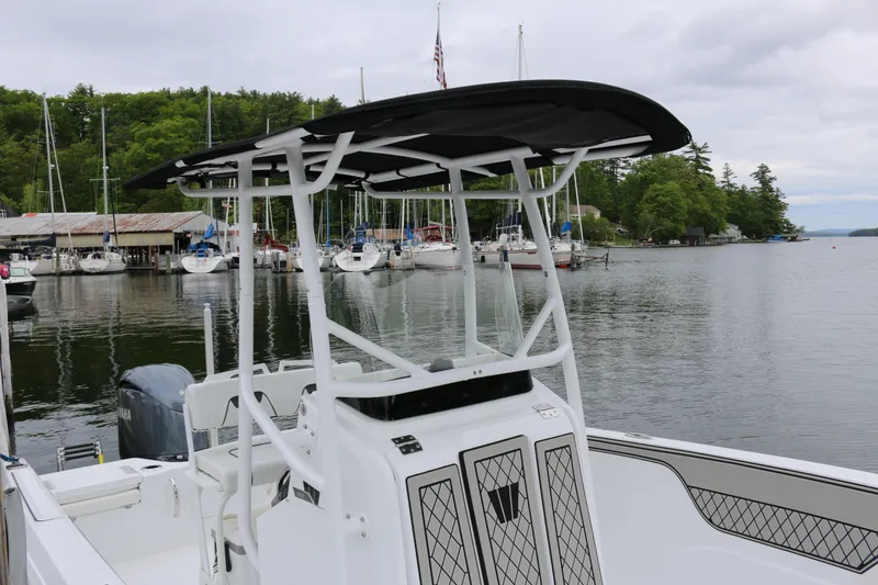 Slide: The Image of 2025 Wellcraft 202 Fisherman boat docked at a scenic marina with sailboats. - 7